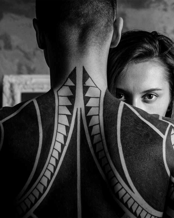 Bold blackwork running across a client’s shoulders and neck
